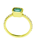 A yellow gold emerald ring displaying the top and lateral side view.