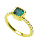 This bezel set natural colombian emerald ring displays the top and accent diamonds on the band design.