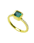 14K yellow gold ring with a bezel-set emerald and accent diamonds on the band.