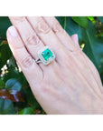 4.14 ct GIA-certified F1 Colombian emerald ring with diamonds in 14K white gold on a hand.