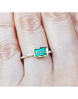 Emerald-cut bezel set natural colombian emerald ring in 14k yellow gold with accent diamonds.