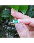 14K yellow gold east-west emerald ring, bezel set, with accent diamonds on the band.