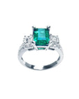 1.88 carat emerald ring with side emerald-cut diamonds and round accents in 18k white gold.