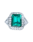 GIA certified 3.98 ct. emerald and diamond ring in 18K white gold with halo and trillion sides.