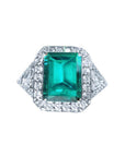 GIA certified 3.98 ct. emerald and diamond ring in 18K white gold with halo and trillion sides.