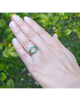 Hand wearing a 14K yellow gold emerald ring guard with 0.75 ct. round-cut Colombian emeralds.