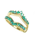 A tilted position of a yellow gold emerald enhancer ring on a white background.