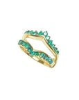 A tilted position of a yellow gold emerald enhancer ring on a white background.