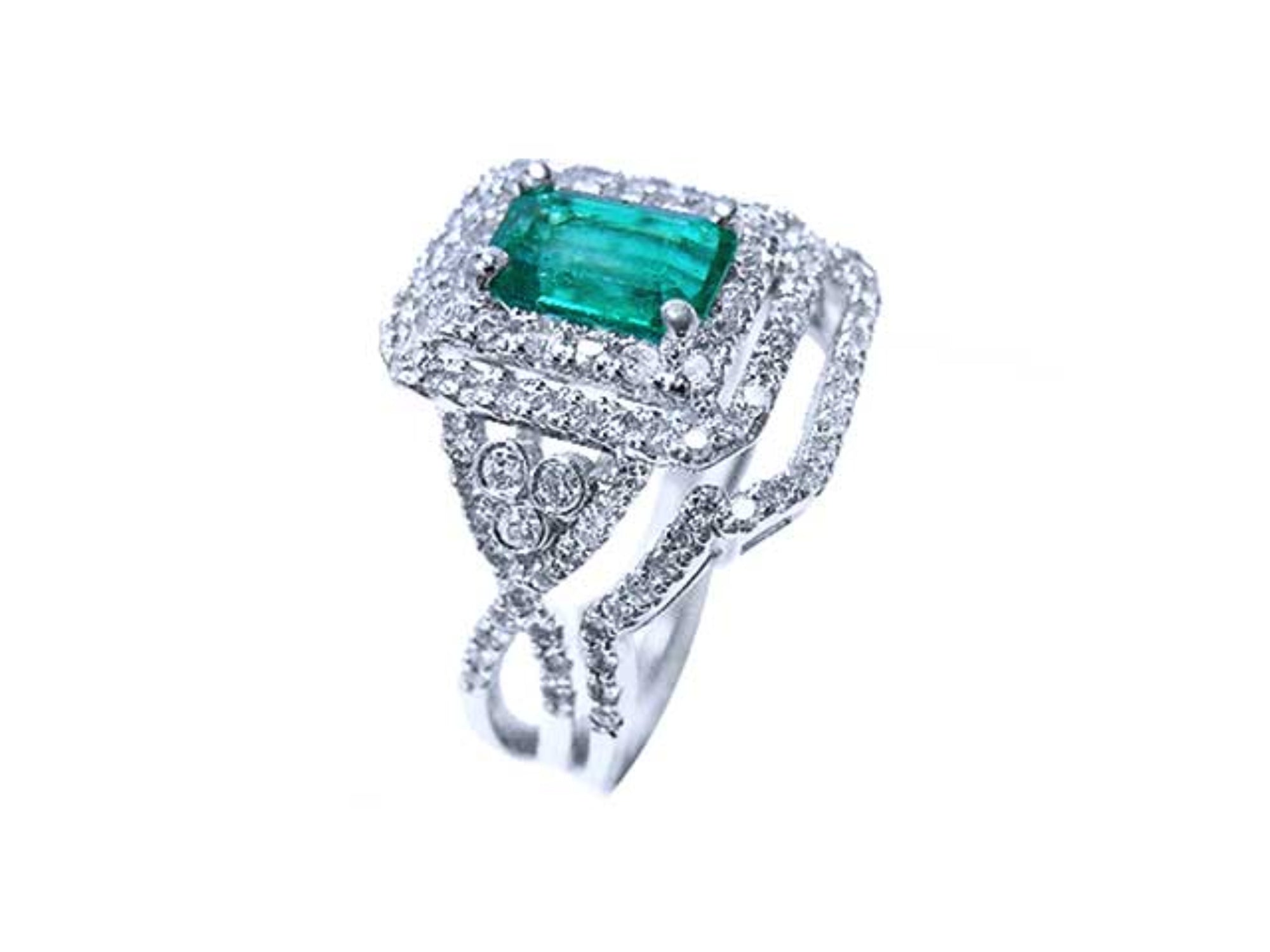 This Colombian emerald is into a double halo diamond on top of a white gold ring, side profile visibles.