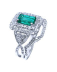 This Colombian emerald is into a double halo diamond on top of a white gold ring, side profile visibles.