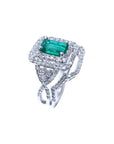 This Colombian emerald is into a double halo diamond on top of a white gold ring, side profile visibles.