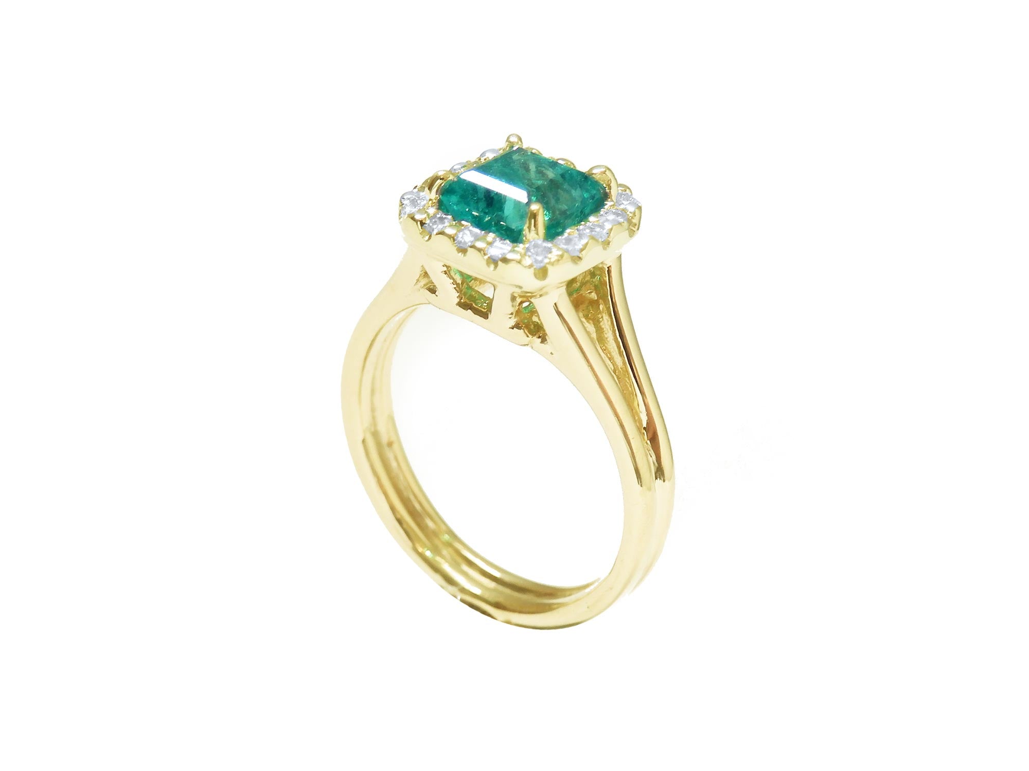 From its half side view this yellow gold emerald ring is visibles the top and split shank profile.