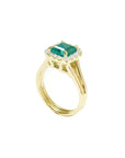 From its half side view this yellow gold emerald ring is visibles the top and split shank profile.