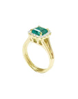 1.27 carat Colombian emerald ring in 14K yellow gold with halo diamonds and a split shank.