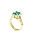 1.27 carat Colombian emerald ring in 14K yellow gold with halo diamonds and a split shank.
