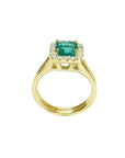 14K yellow gold ring with a square-cut Colombian emerald haloed by diamonds on a split shank.