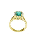 14K yellow gold ring with a square-cut Colombian emerald haloed by diamonds on a split shank.