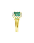 A yellow gold square emerald with halo diamond ring displaying the top and split shank side profile.