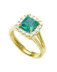 The tilted position of this square emerald ring displays the halo diamond and side shank profile.