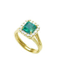1.27 carat Colombian emerald ring in 14K yellow gold with halo diamonds and a split shank.