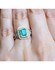 A bridal emerald engagement ring with double halo diamonds in 14k yellow gold.