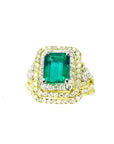 This Colombian emerald ring with matching band has a double halo of diamonds and it was crafted in 14k yellow gold.