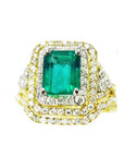 This Colombian emerald ring with matching band has a double halo of diamonds and it was crafted in 14k yellow gold, topside view.