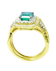 A 14k yellow gold emerald ring and diamond accents on a white background.