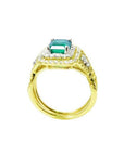 1.31 ct emerald-cut emerald ring with double diamond halo and matching band in 14K yellow gold.