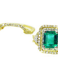 Topside of an emerald-cut emerald ring with double halo diamond and aside the matching band.