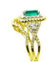 A side profile view of a natural emerald ring with the matching band and accent diamonds in yellow gold.