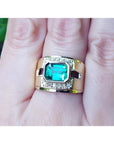 Men's 18K yellow gold ring with a rectangular emerald and diamond accents on a finger.