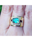 Men's 18K yellow gold ring with a rectangular emerald and diamond accents on a finger.