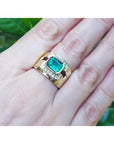 Men's 18K yellow gold ring with a rectangular emerald and surrounding diamonds on a hand.