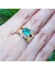 Men's 18K yellow gold ring with a rectangular emerald and surrounding diamonds on a hand.