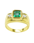 Men's gold ring with a rectangular emerald-cut emerald and two diamonds on a white background