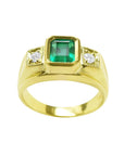 Men's 18K yellow gold ring with a bezel-set emerald and two side diamonds.