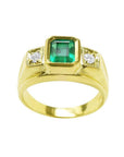 Men's 18K yellow gold ring with a bezel-set emerald and two side diamonds.