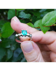 0.76 ct. square emerald cut Colombian emerald ring with side diamonds on a 14K white gold band.