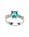 White gold emerald with accent diamonds ring on a white background.