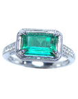 The topside of this natural emerald and diamond ring displays the center of the main gemstone and sides of the band design.