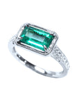 Ring with a natural colombian emerald and diamond accents on a white background