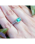 1.21 ct. emerald-cut emerald ring with natural diamonds on a 14K white gold band, worn on a hand.