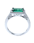 The lateral view of this natural emerald and diamond ring displays its lateral top setting and gallery design.