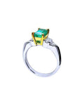 Platinum and 18K yellow gold emerald ring with round and trillion-cut diamond accents.
