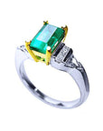 Platinum emerald ring and yellow gold setting on a white background,