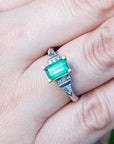 Close-up of a hand wearing an emerald ring with a natural colombian emerald.