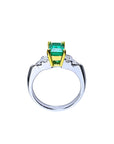 Platinum ring with 1.21 ct emerald in 18K yellow gold setting, flanked by diamond accents.