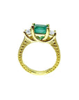 18K yellow gold ring with a rectangular emerald center stone and princess-cut side diamonds, antique decor.