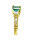 Emerald and princess cut diamond women's ring displaying it side profile from top to down.